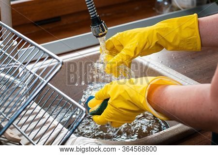 Image Of A Middle Aged Women Is Washing Dishes.