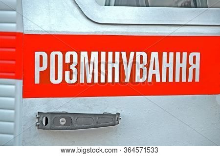 Mine clearance aka demining aka lifting the mines as text on ukrainian language on metal car surface, modern security diversity