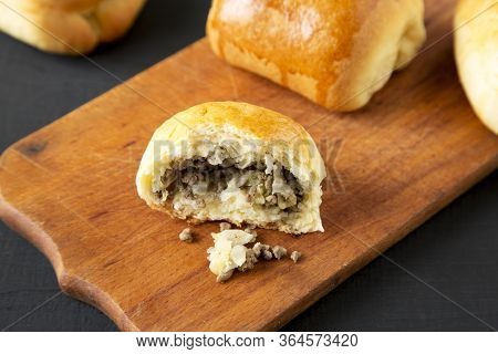 Home-baked Beef Russian Bierocks On A Rustic Wooden Board On A Black Surface, Low Angle View. Close-