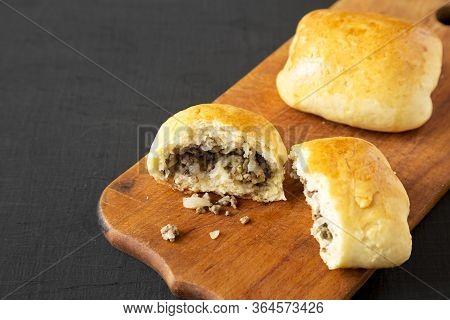 Home-baked Beef Russian Bierocks On A Rustic Wooden Board On A Black Surface, Side View. Copy Space.