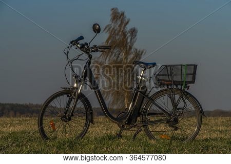 Black Electric Bike On Ski Slope In Budweis City With Windy Trees