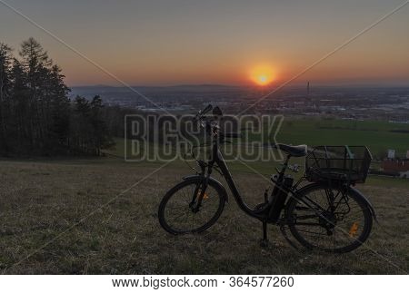 Black Electric Bike On Ski Slope In Budweis City With Sunset