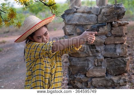 Portrait The Farmer Asea Woman Wearing A Yellow Shirt Hand Holding Old Revolver Gun In The Farm, You