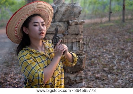 Portrait The Farmer Asea Woman Wearing A Yellow Shirt Hand Holding Old Revolver Gun In The Farm, You