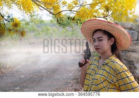 Portrait The Farmer Asea Woman Wearing A Yellow Shirt Hand Holding Old Revolver Gun In The Farm, You
