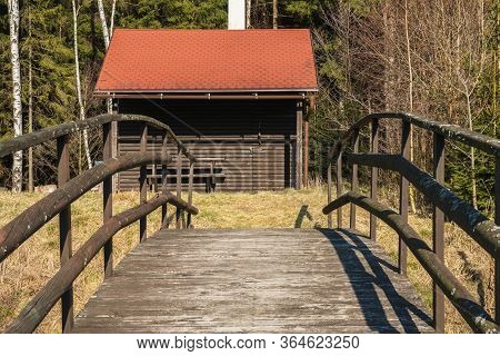 Fishermans House With A Wooden Pedestrian Bridge On A Tiny Island In The Middle Of The Lake. Autumn 