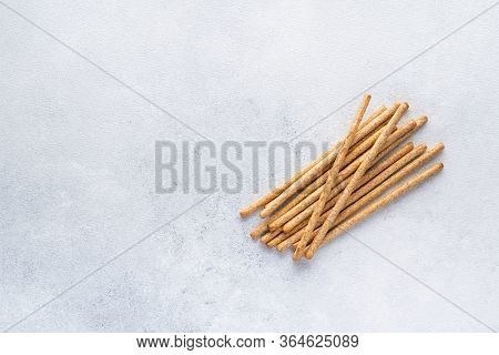 Organic Italian grissini or salted bread sticks and bread lying on a gray background. Fresh Italian 