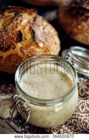 A Jar With Active Rye Sourdough For Baking Bread On A Wooden Table, Close Up