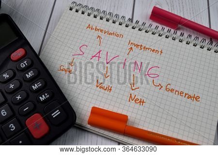 Saving Write On A Book With Keywords Isolated On Wooden Background. Finance Concept