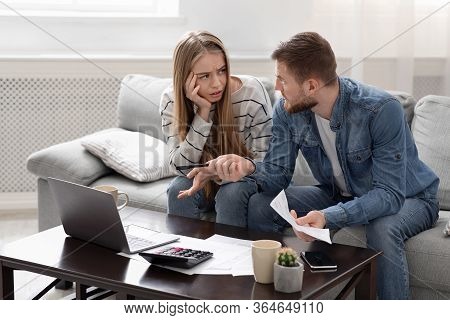 Coronacrisis Concept. Young Couple Calculating Their Financial Bills At Home, Empty Space