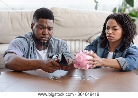 Coronacrisis Concept. Desperate African Couple Counting Last Money At Home, Shaking Out Coins From W