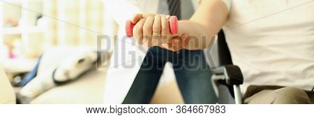 Male Doctor Helps Lift Dumbbell To Disabled Patient Rehabilitation Therapy Concept. Process Of Recov