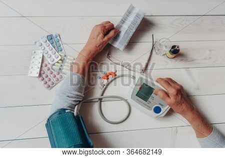 Senior Wrinkled Hands With Blood Pressure Measure Cuff, Medicine Bottle, Glass, Colorful Pills, Ther