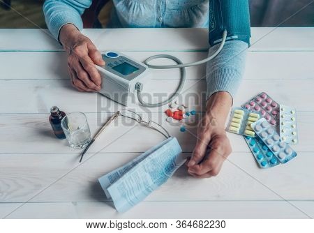 Senior Wrinkled Hands With Blood Pressure Measure Cuff, Medicine Bottle, Glass, Colorful Pills, Ther