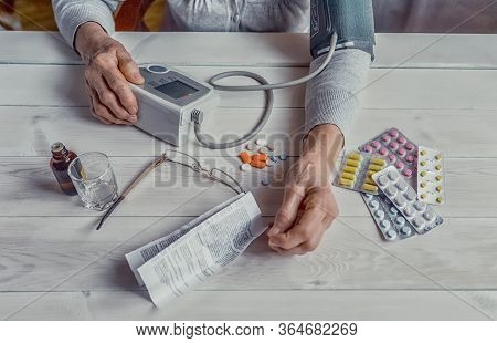Senior Wrinkled Hands With Blood Pressure Measure Cuff, Medicine Bottle, Glass, Colorful Pills, Ther