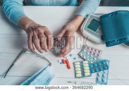Senior Wrinkled Hands With Blood Pressure Measure Cuff, Medicine Bottle, Glass, Colorful Pills, Ther