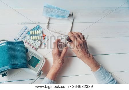 Senior Wrinkled Hands With Blood Pressure Measure Cuff, Medicine Bottle, Glass, Colorful Pills, Ther