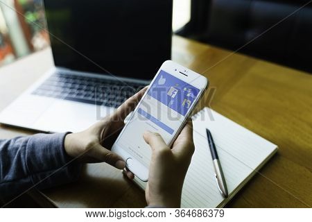 Chiang Mai, Thailand - Feb.23,2020: Man Holding Apple Iphone With Facebook App On The Screen. Facebo