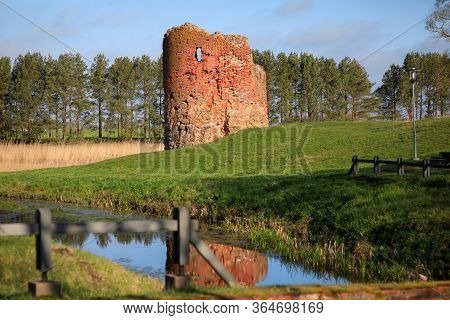 Old Collapsed Tower Of A Water Mill On The River Bank On A Clear Sunny Day, Piltene, Latvia