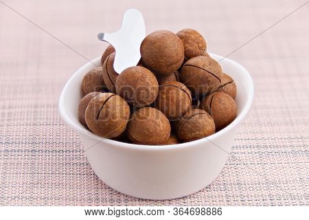 Delicious Macadamia Nuts On  Plate On  Wooden Background