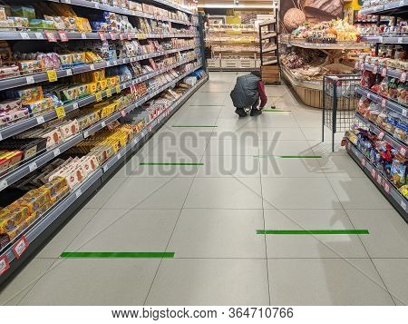 Tver, Russia - 04 29 2020: A Supermarket Employee Tapes Social Distancing Lines Across A Supermarket
