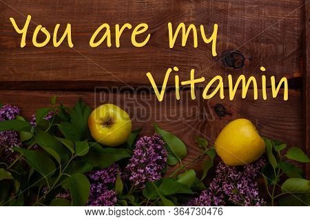 Bright Yellow Apples, Purple Lilac Flowers With Fresh Green Leaves On Wooden Background Flat Lay.col