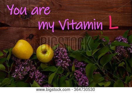 Bright Yellow Apples, Purple Lilac Flowers With Fresh Green Leaves On Wooden Background Flat Lay.col