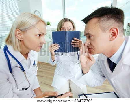 Porträt des männlichen Kliniker und sein Kollege, der Konspiration mit Angst Mitarbeiter in der Nähe von