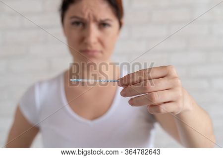 Unhappy Woman Shows A Quick Negative Test For Ovulation. The Concept Of Violation Of Female Reproduc