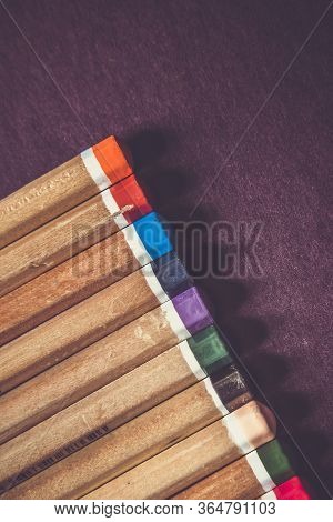 School Supplies On Dark Background. Back To School Background. Notepad And Stack Of Colorful Pencils