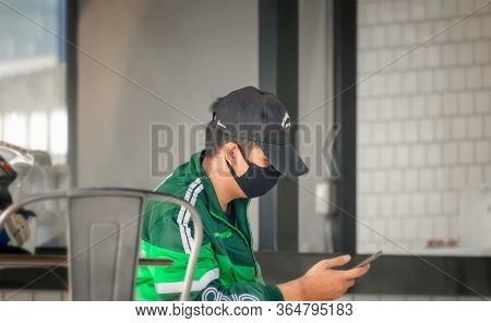 Bangkok, Thailand - May 02: Delivery Grab Rider Waits And Checks Mobile For Orders In Bangkok On May