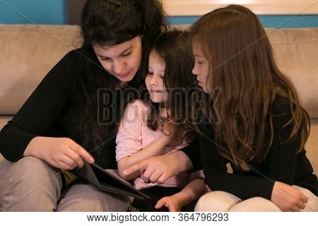 Mother Doing Lessons With Children On A Tablet