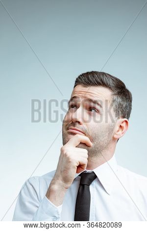 Young Man With A Smirk And His Hand To His Chin