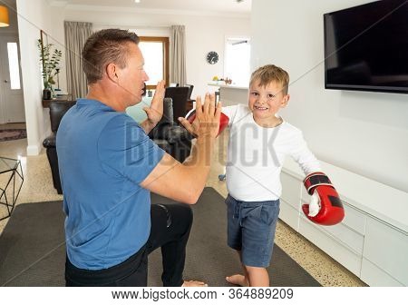 Covid-19 Shutdown. Father And Son Having Fun Boxing Together And Staying Physically Active At Home D