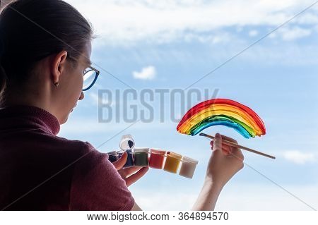 Girl Paints A Brush And Paints A Rainbow On The Window Sky, Clouds, The End Of Quarantine, Self-isol
