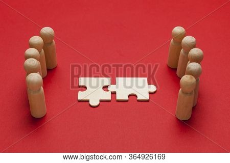 Wooden Figures With Pazzles On Red Background. Agreement Between Business Mans, Cooperation And Deal