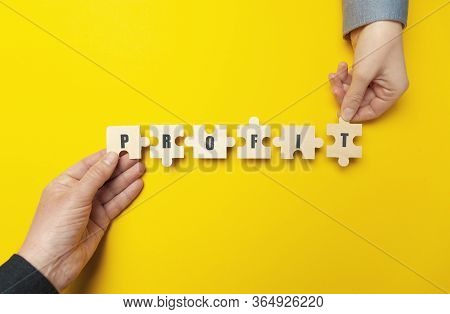 Hands Of Businessmen Are Holding A Puzzle With The Word 