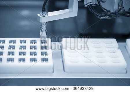 The Robotic System Picking Up The Automotive Fuse Parts To The Container Box. The Automatic Material