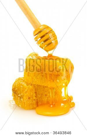 honeycombs ทองและไม้ drizzler น้ำผึ้งแยกต่างหากบนพื้นสีขาว