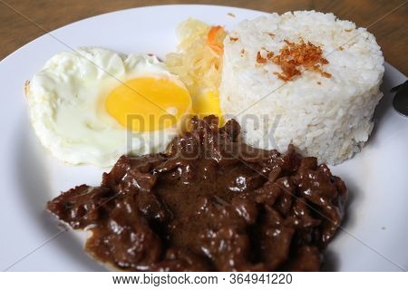 Tapsilog Breakfast - Typical Morning Food In Philippines. Garlic Rice, Fried Egg And Cured Beef Tapa