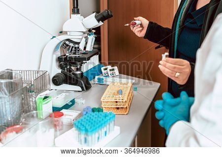Working In The Lab, Professor Teaching Student About Using Micropipette