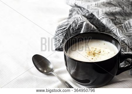 Cauliflower Soup (creme Du Barry) In Black Bowl On White Background With Black And White Cloth. Copy