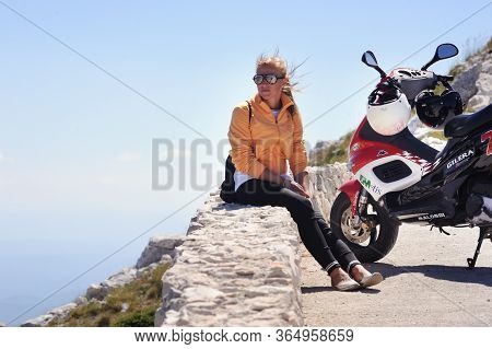 Split, Croatia - July 12, 2019:the Girl On The Gilera Scooter Stopped In The Mountains Of Croatia. A