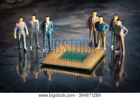 Group Of Miniature Model Of Businessmen Standing Around The Cpu In A Reflective Surface. Microelectr