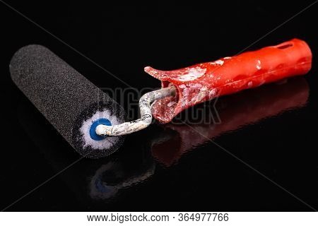 Paint Roller And Black Paint. Painting With Black Paint On A Flat Surface.