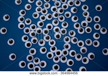 Googly Toy Eyes On Classic Blue Background. Concept Of Personal Data Security, Surveillance, Espiona