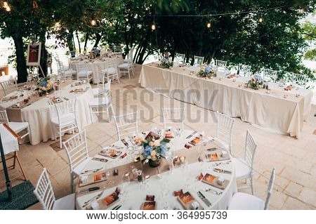 Wedding Dinner Table Reception. Round Tables With White Tablecloths, Brown Runners, Bouquets Flowers