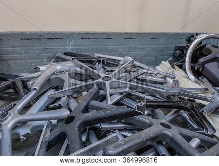 Collection Of Metal And Plastic Broken Office Chair Bases In Back Of Truck.