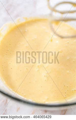 Mixing Ingredients In A Large Glass Mixing Bowl To Bake Apple Sharlotka Muffin.