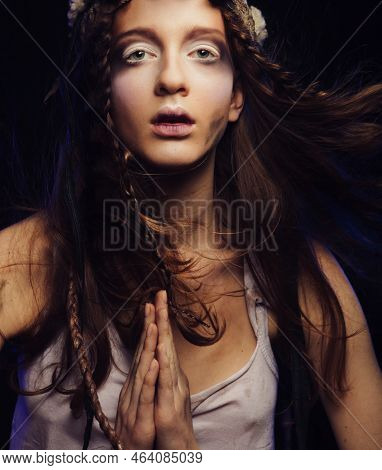 A Young Woman With Bright Make-up, Braided Hair And A Skull On Her Head Stands With Her Palms Folded